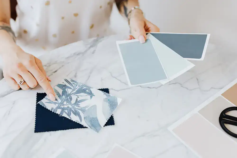 An editorial studio desk with fabric swatches and design magazines